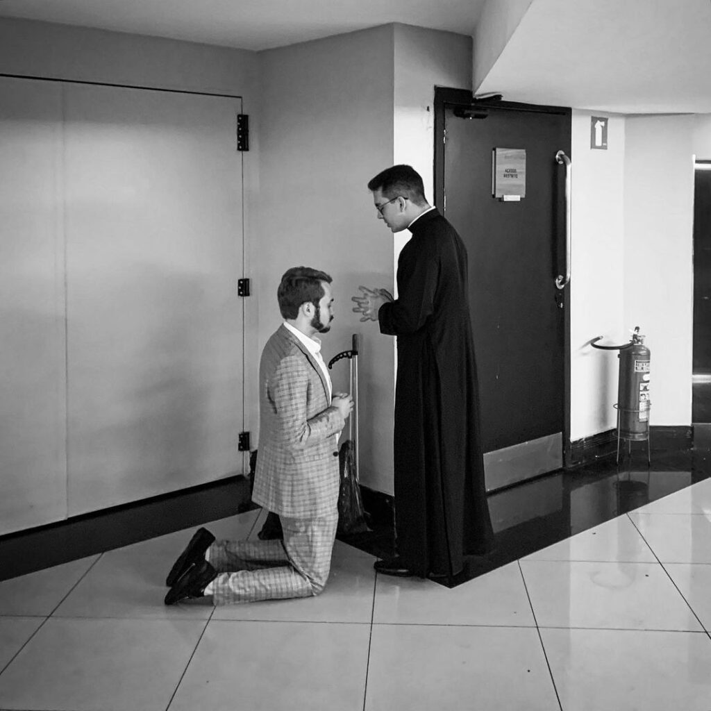 sacerdote con sotana confesando